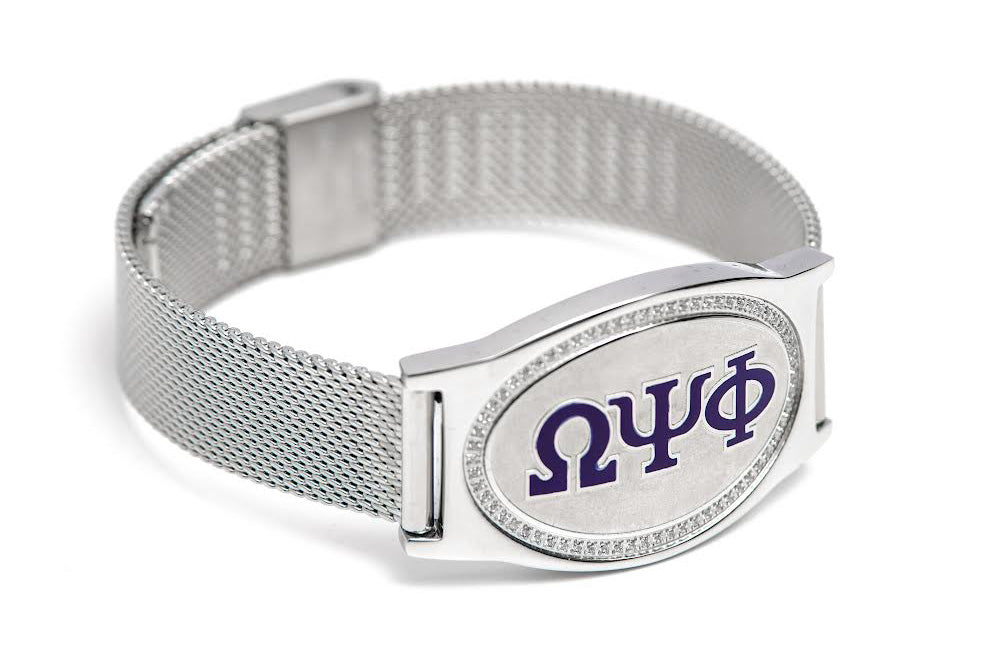 Omega Psi Phi Legacy Bracelet featuring Greek letters ΩΨΦ in royal purple enamel on a brushed silver plaque with a woven silver mesh band.