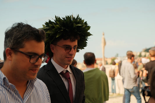 Man wearing laurel wreath at graduation ceremony
