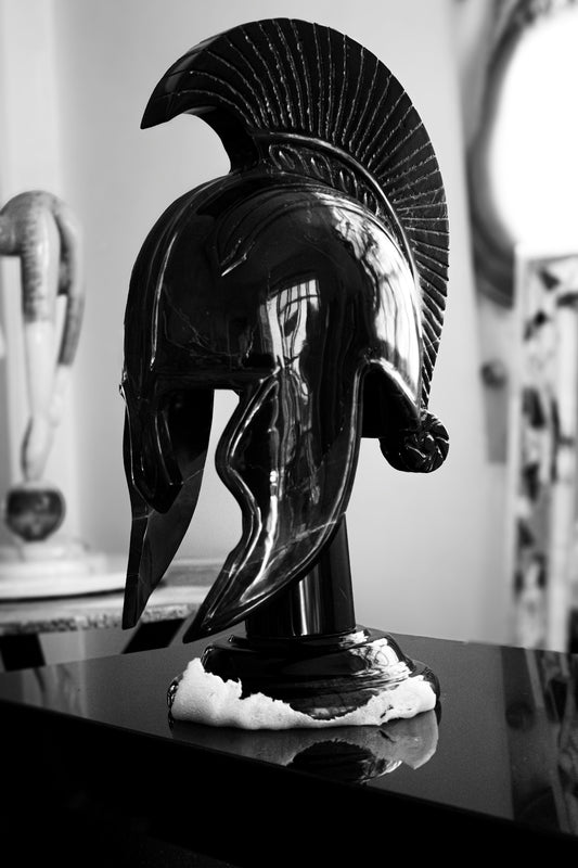 A black ancient greek helmet on display